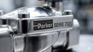 Un primer plano macro de una válvula de acero inoxidable Parker (Serie 7321) donde se aprecie el brillo del metal y el grabado láser del logo, sugiriendo pureza, calidad y resistencia industrial extrema.